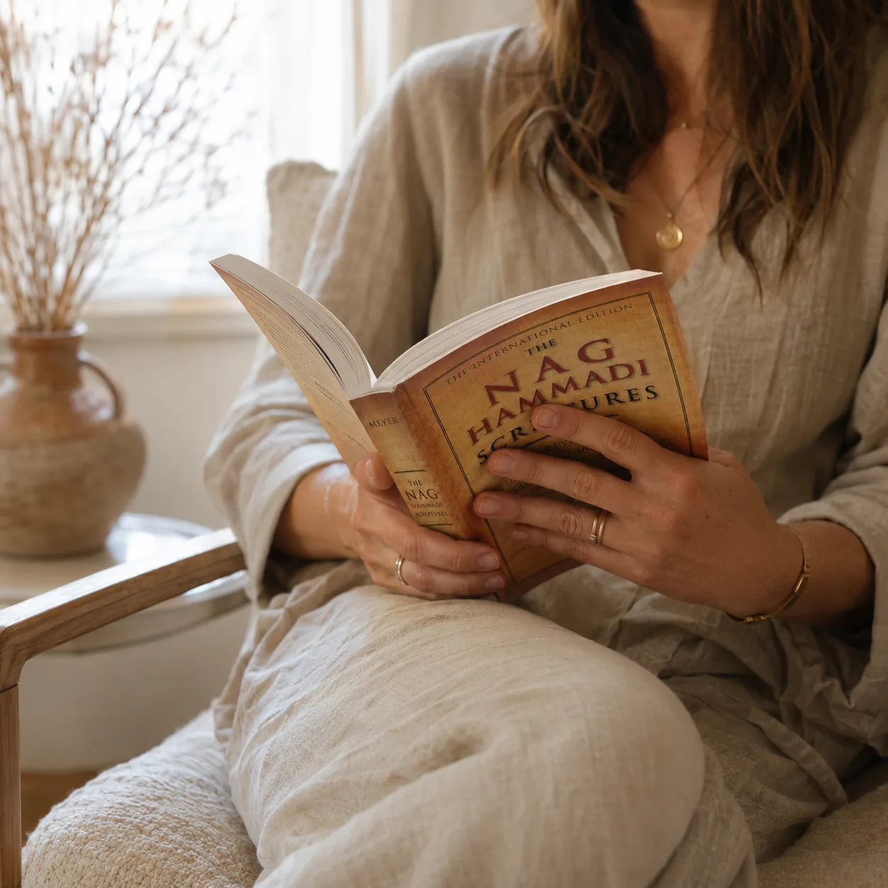 Reading the paperback naturally in a linen armchair