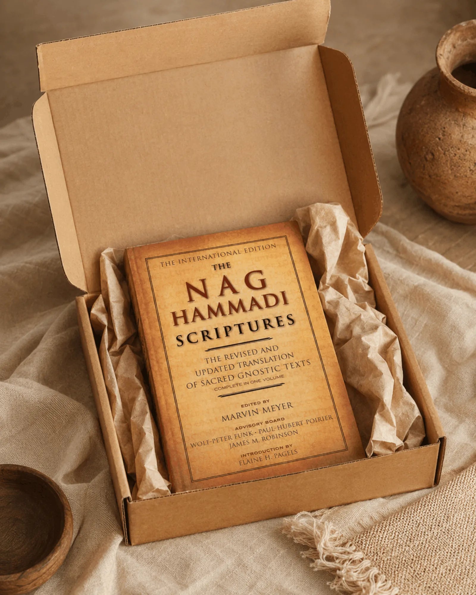 The book arriving in its kraft shipping box, wrapped in paper