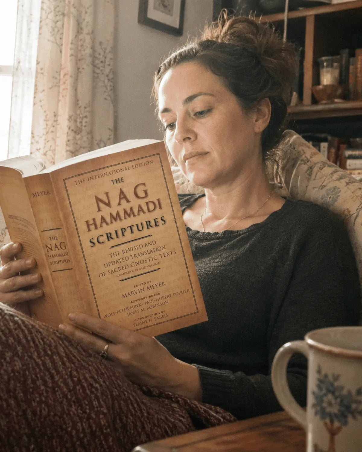 Reading the paperback on a sofa in soft window light