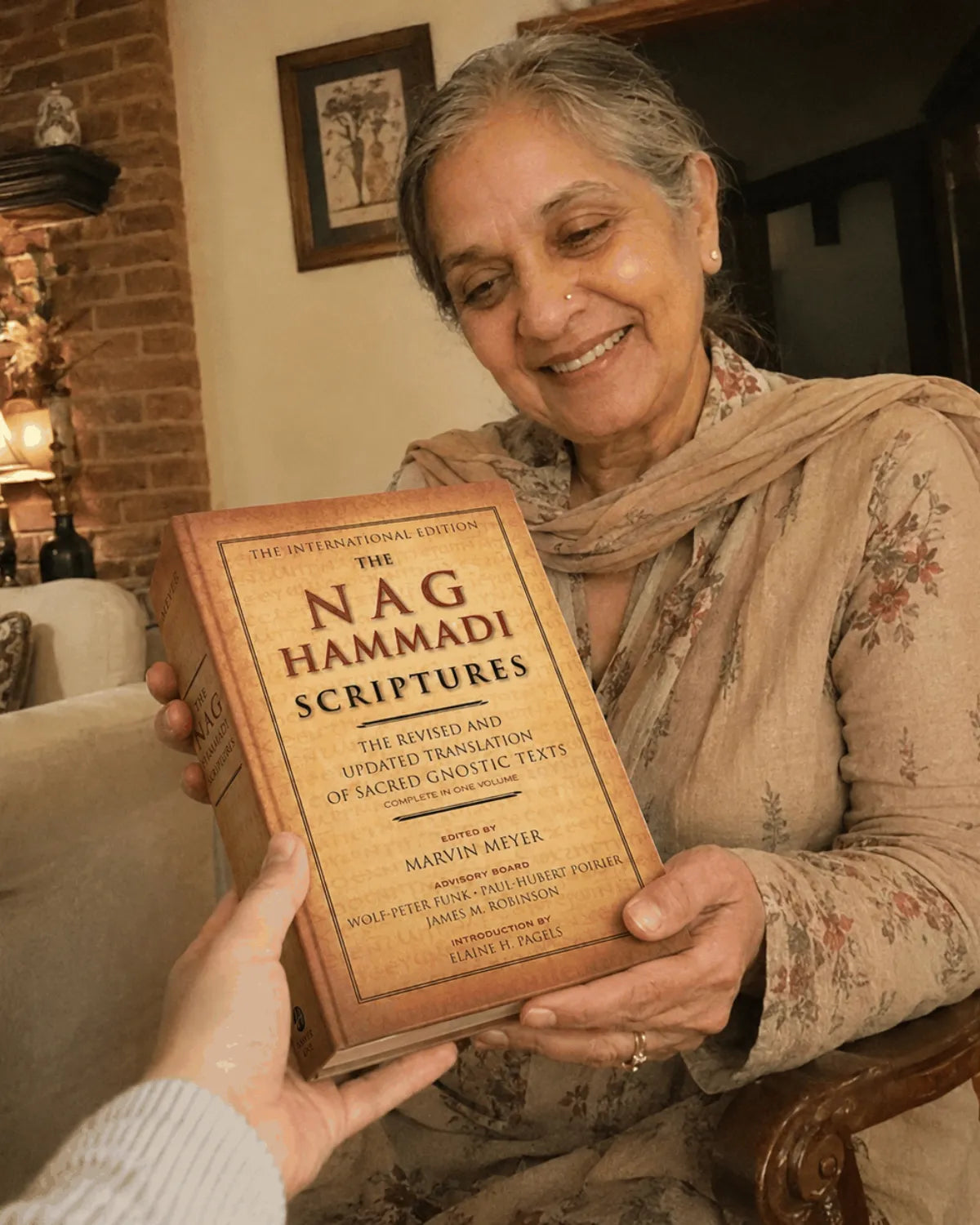 Handing the book to an older reader in her living room