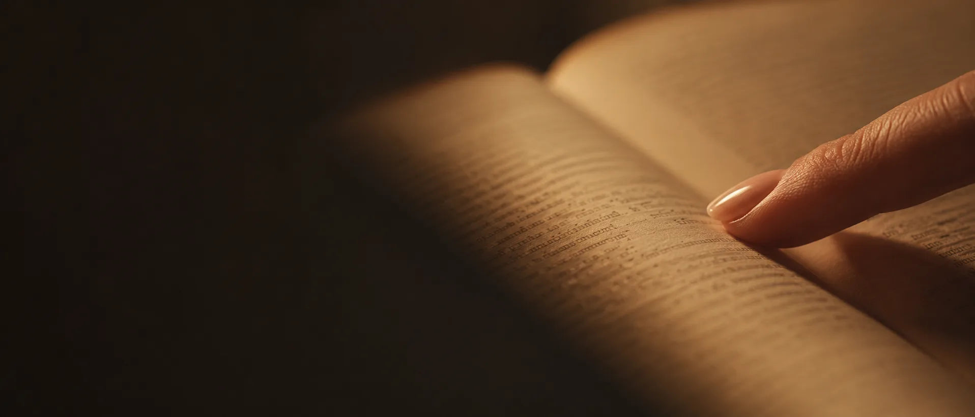 A fingertip resting on a line of the open book