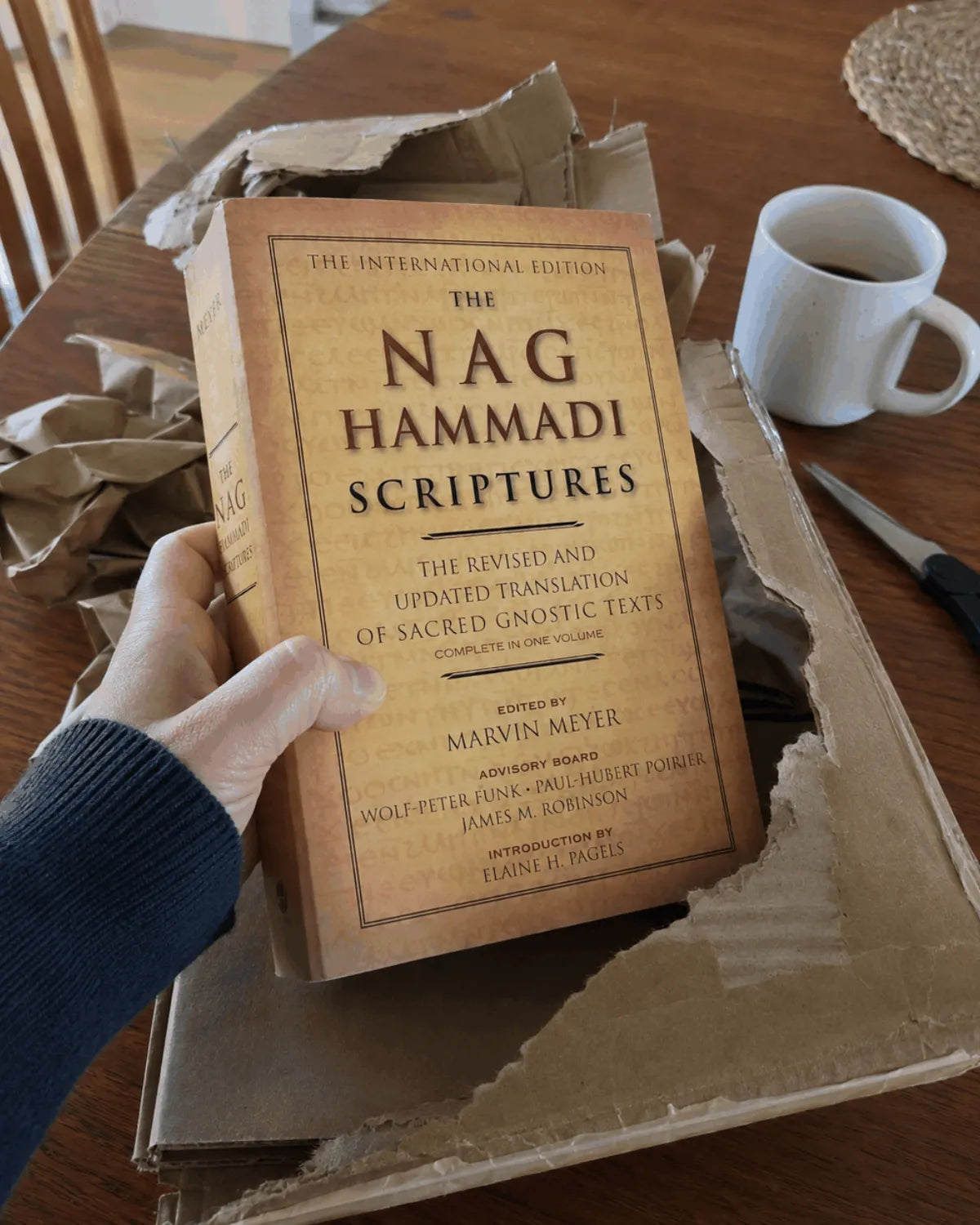Hands lifting the book out of its kraft shipping box