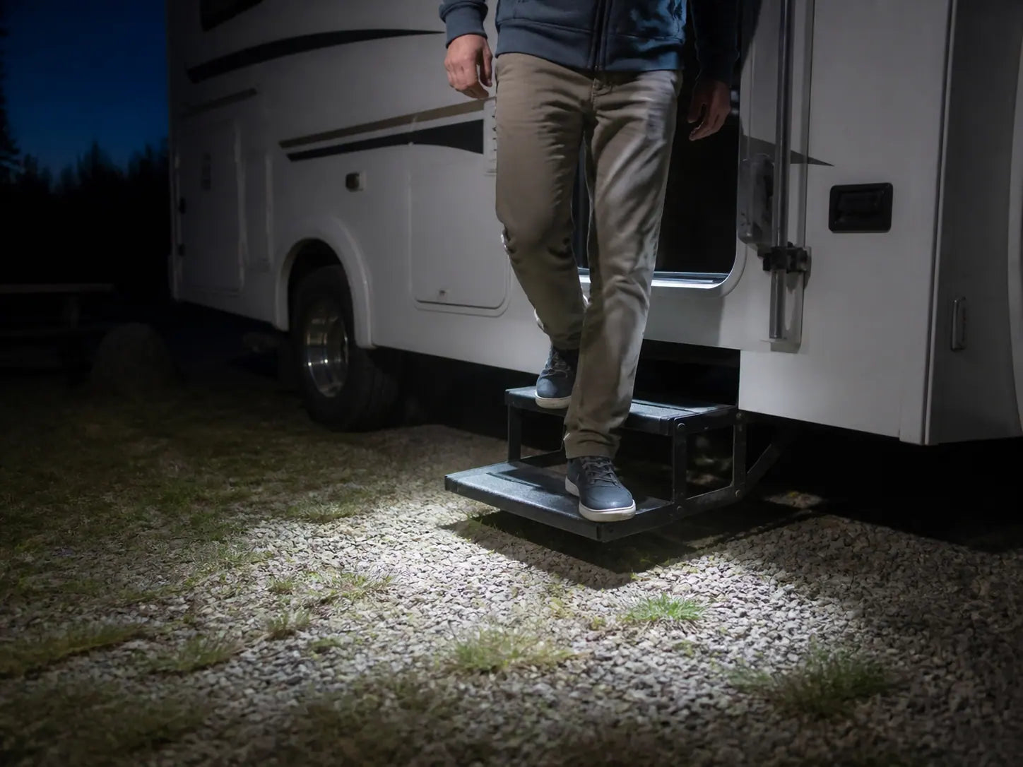 Stepping down from the RV doorway onto lit steps at night
