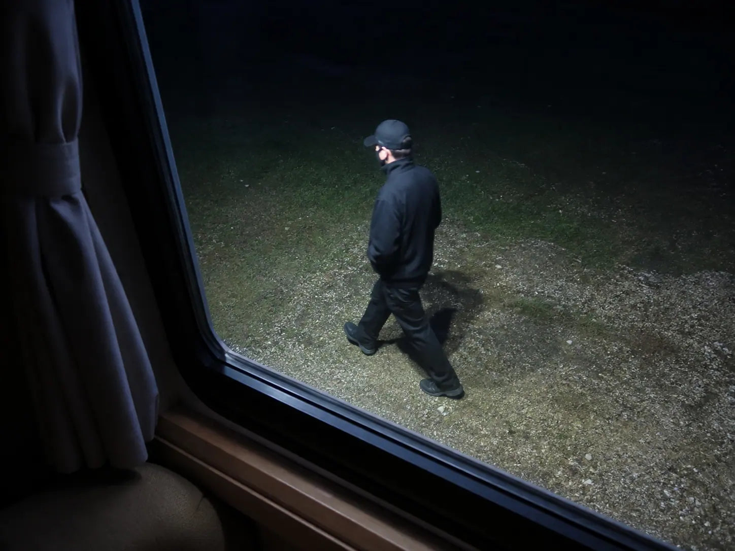 Looking out the RV window at a lit area outside